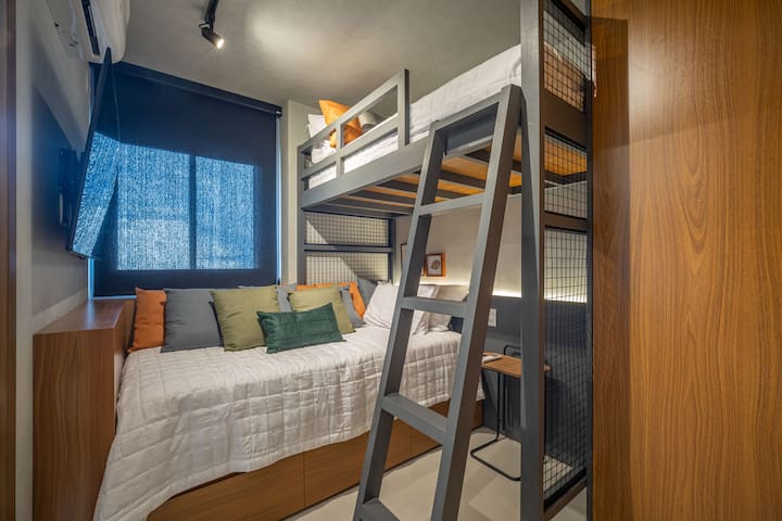 Quarto suíte com beliche, duas camas twin confortáveis, TV, iluminação aconchegante e design moderno