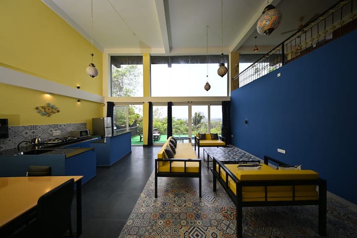 The shared living room is on the ground floor with a main kitchen and dining table. There is an 8-seater sofa with Moroccan-style coffee tables, lamps & flooring. The huge living room opens to a beautiful sundeck with a swimming pool and valley view