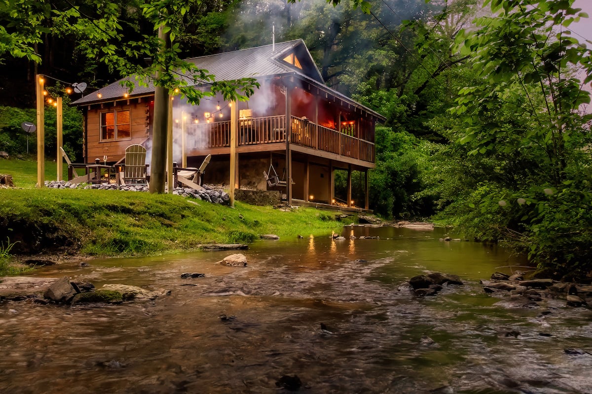 Front exterior of Whispering Creek Cottage nestled among trees