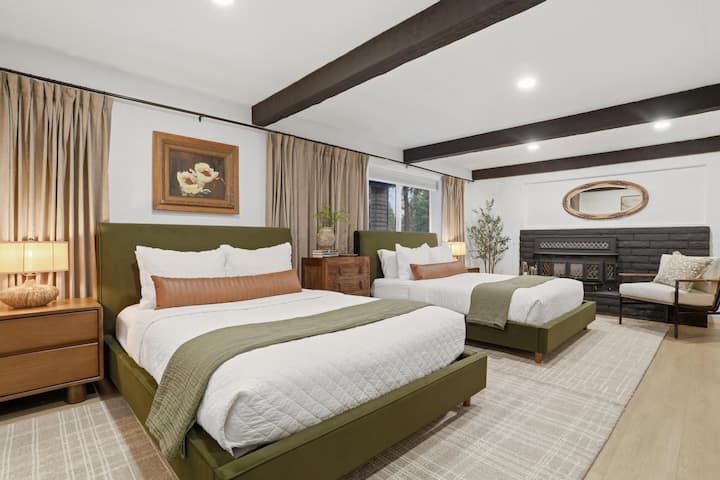 Amplia habitación con dos camas tamaño queen, chimenea, vigas y cómodos asientos