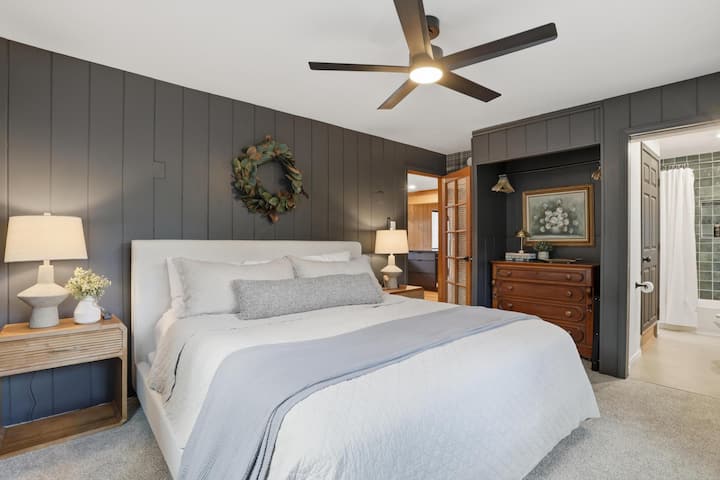 Acogedora habitación con cama tamaño king, elegantes paredes oscuras y baño privado en suite