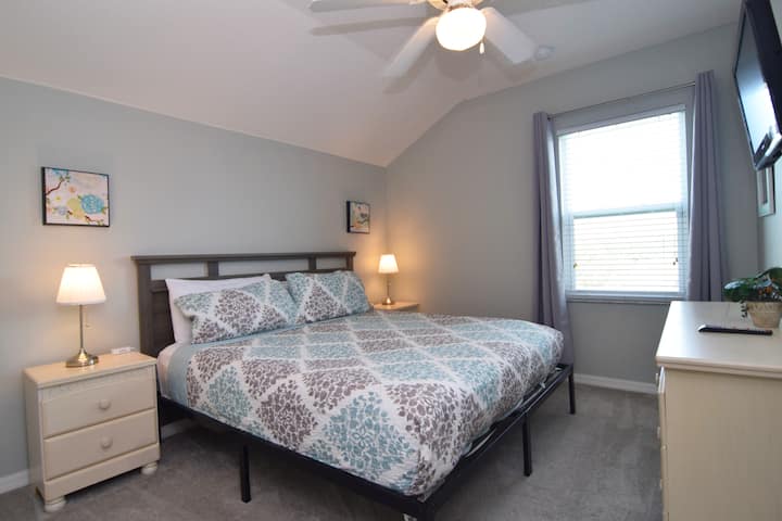 King room with TV and ceiling fan