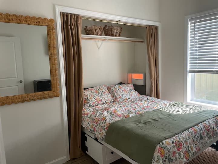 Lit queen size avec salle de bain juste à côté de la porte.
