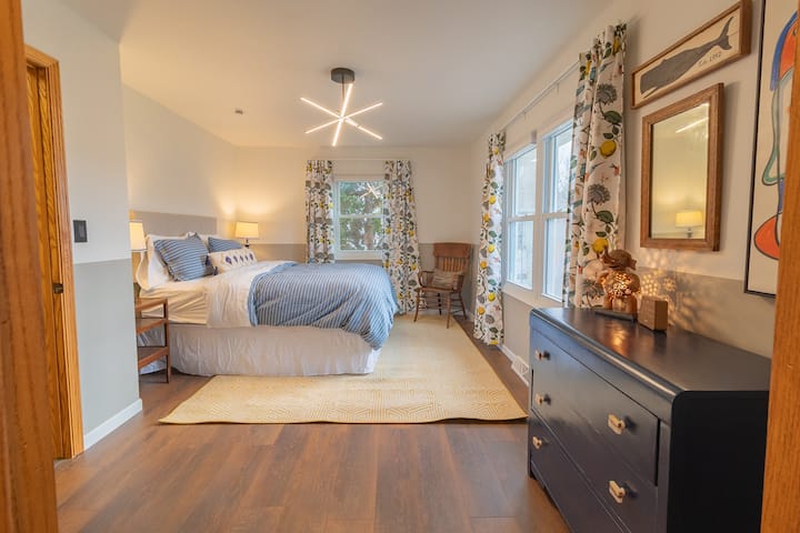 Spacious queen bedroom with abundant natural light - yellow door unit
