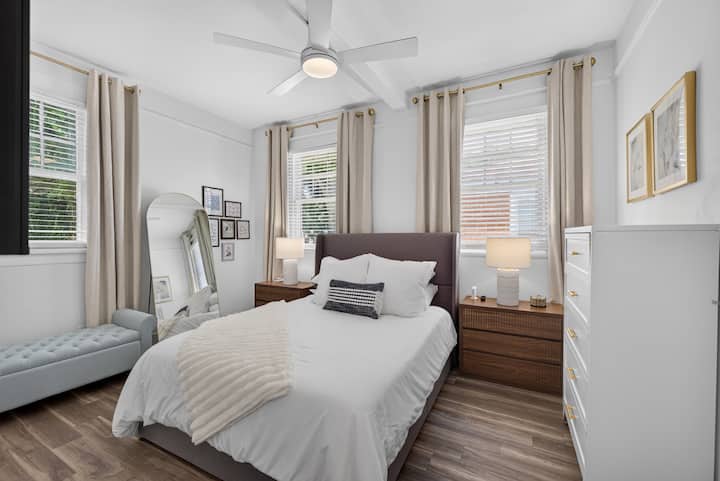 Habitación iluminada y cómoda con cama tamaño queen, amplio espacio de almacenamiento, ventilador de techo y mucha luz natural.
