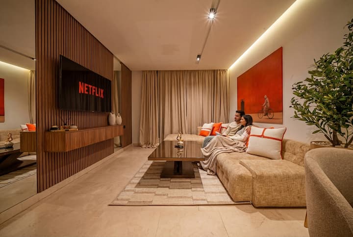 Televisor de 55” con Netflix - Sofá cómodo - Cojín decorativo - Mesa de centro grande - Cortinas - Cuadros - Iluminación - Alfombra de alta calidad