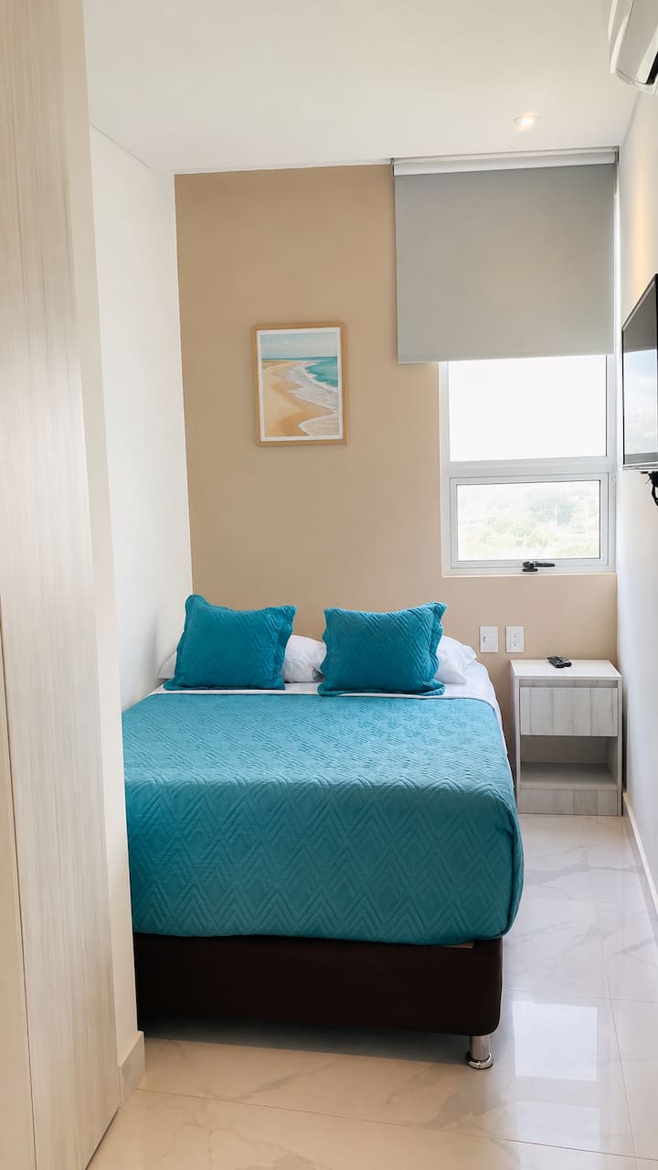 Habitación auxiliar con TV, armario y espacio cómodo para descansar.