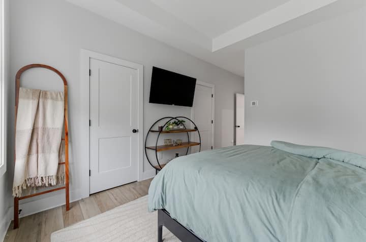 El dormitorio principal también cuenta con un televisor montado, una cama tamaño queen, un baño privado en suite y un clóset extragrande.