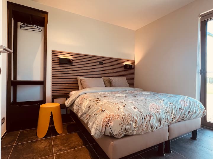 opgemaakt 2-persoonsbed ( op aanvraag: 2 aparte eenpersoonsbedden) met een ensuite badkamer met ruime douche en lavabo