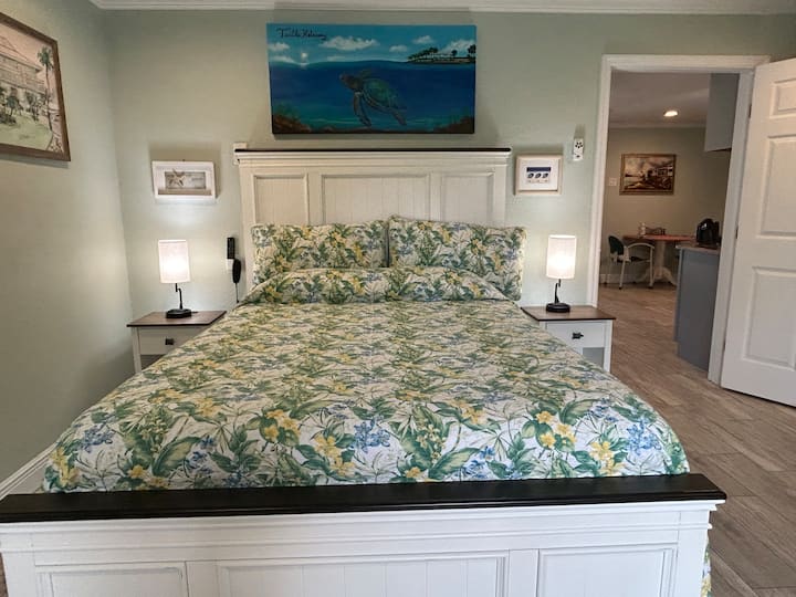 המיטה שלכם תהיה כרית מתכווננת קווין ושני שולחנות צדדיים עם מנורות טעינה כפולות לטלפון.