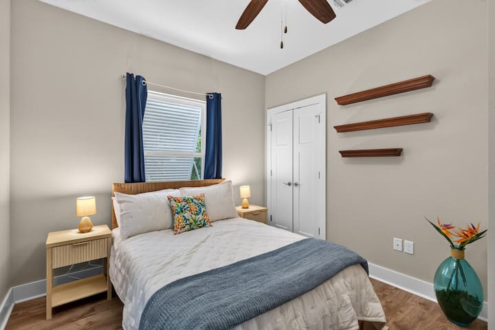 A cozy retreat with a comfortable full-size bed, soft linens, bedside lamps, blackout curtains, and a ceiling fan—perfect for unwinding after a fun day on the Gulf Coast.