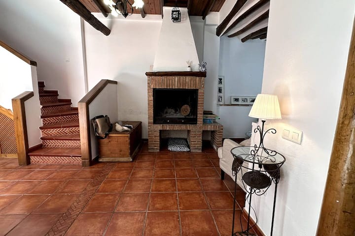Chimenea de leña bajo techos de vigas centenarias: el rincón favorito en invierno