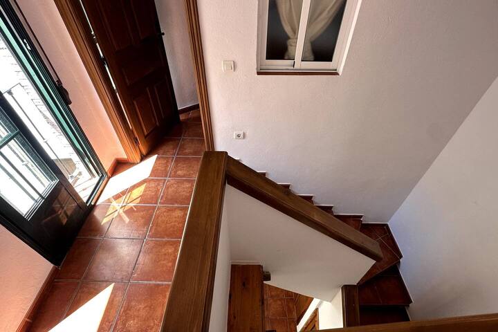 Escalera de la casa con suelo de barro: distribución en varias plantas con encanto andaluz.