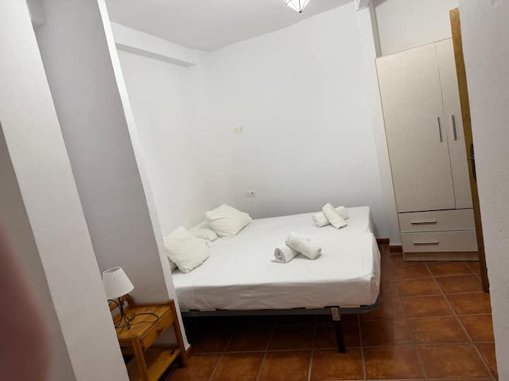 Dos camas individuales con toallas preparadas y armario propio
