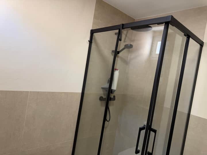 Mampara de cristal y perfil negro, con doble rociador de ducha