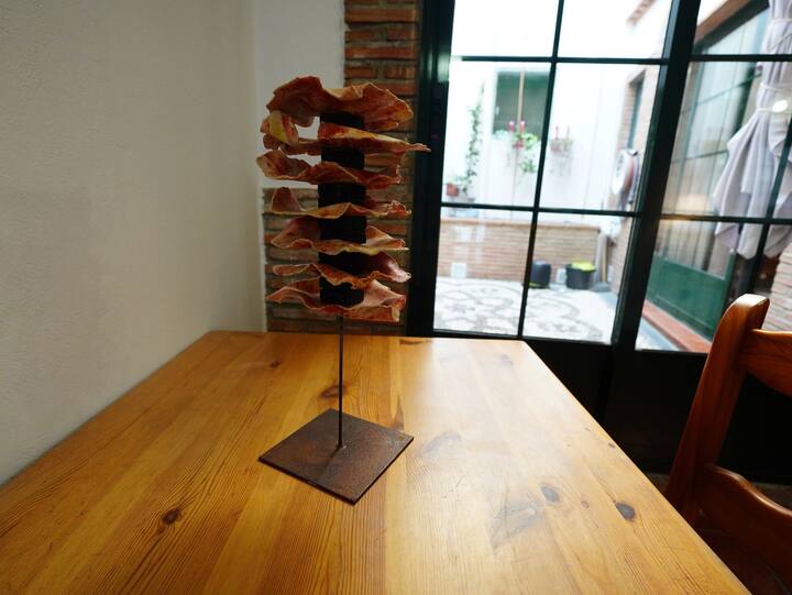 Detalle del comedor con jamonero y ventanal al patio: mucho sabor local.