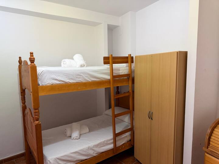 Literas de madera con toallas y ropa de cama listas a la llegada