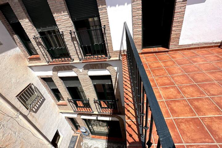 Suelo de barro cocido y barandilla de hierro: sol de mañana asegurado