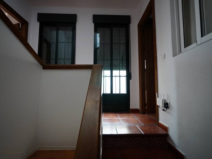 Escalera junto a la ventana con suelo de barro: distribución práctica y luminosa.
