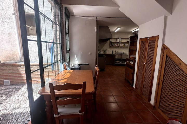 Espacio diáfano entre patio, cocina y escalera: la casa fluye alrededor del comedor
