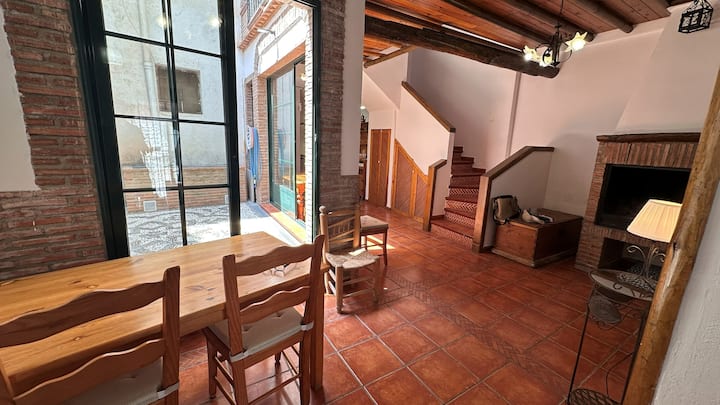 Mesa para diez entre ladrillo, madera y la luz del patio andaluz