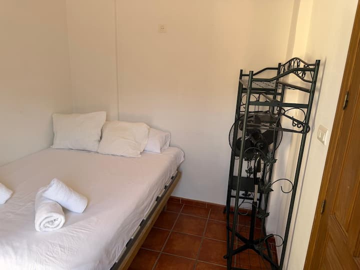 Cama de matrimonio con ropa de cama incluida y ventilador para el verano