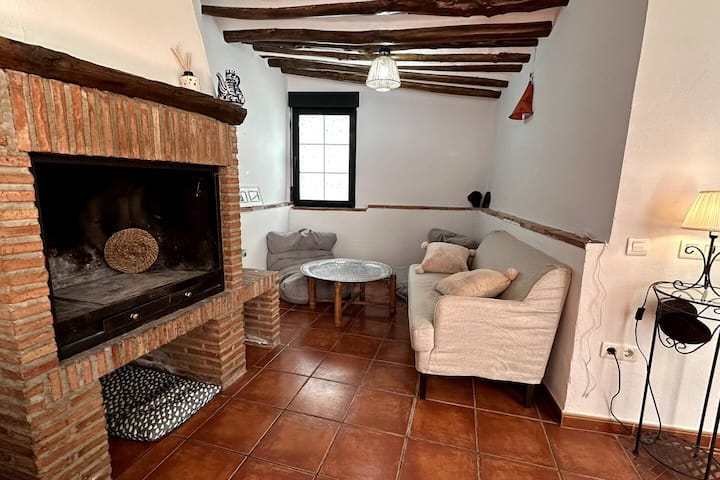 Chimenea de obra vista con leñero: calor de hogar en plena sierra
