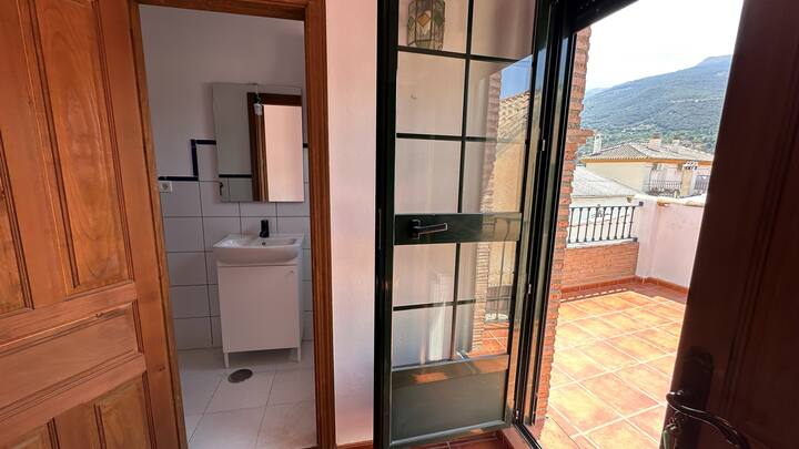 Aseo con lavabo y salida a la terraza con vistas: fresco y con mucha luz.