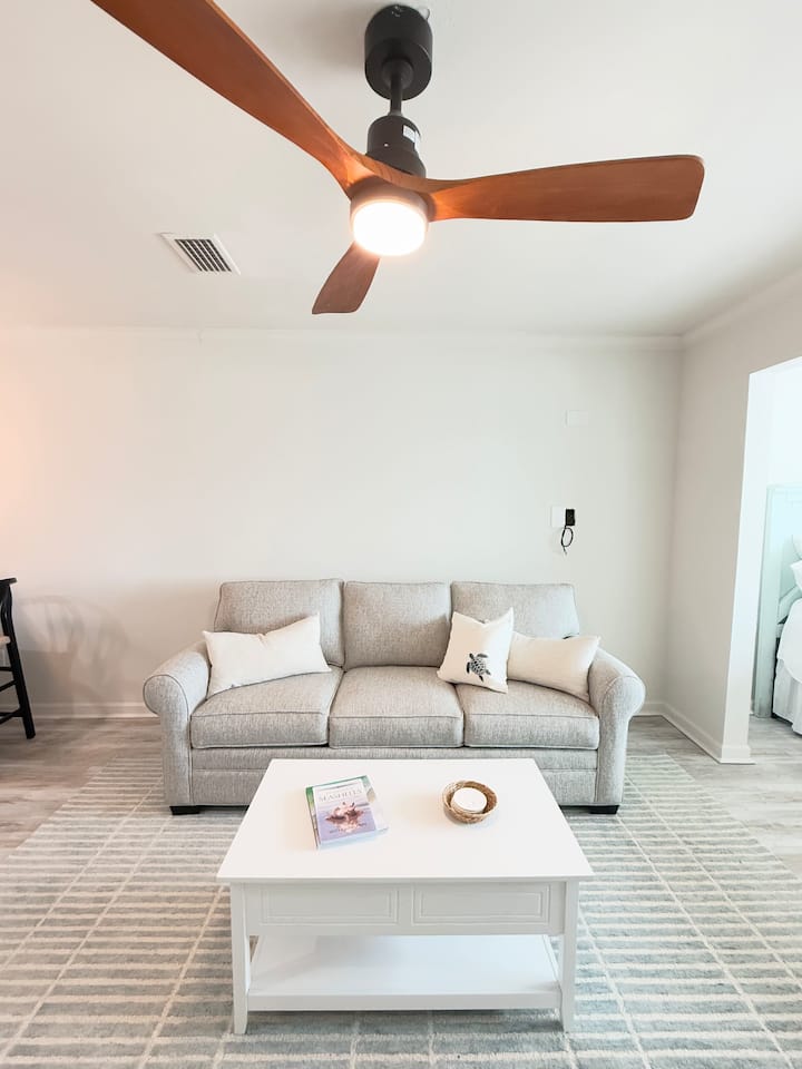 Living room features sleeper sofa with queen bed, rocking swivel recliner, smart TV, overhead fan.