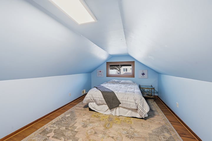 A view of one of upstairs bedroom #2. This room features a queen sized bed, custom closets, and vinyl plank flooring.