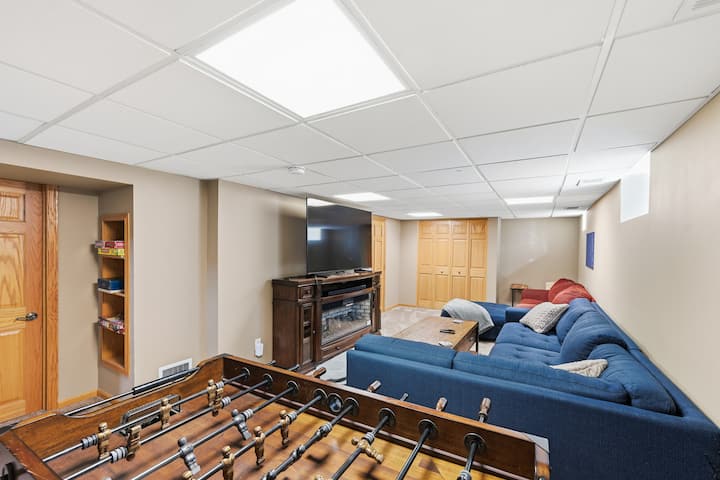 The basement is the perfect hangout space for your group, featuring a 70-inch smart tv, Samsung soundbar and subwoofer, two comfortable sofas, and a foosball table! The basement bathroom is adjacent to the folding wood doors you see in the back.