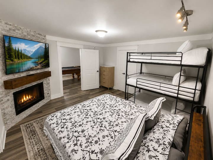 Quarto espaçoso para famílias, com uma cama queen size, beliches e muito espaço para todos se espalharem e relaxarem depois de um dia de aventura.
