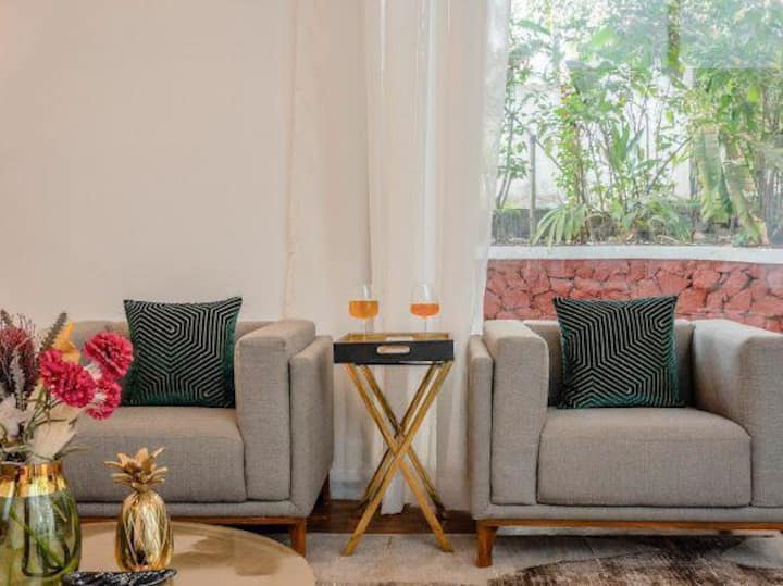 The modern yet cozy seating arrangement, complete with plush sofas and vibrant cushions, creates the perfect setting for unwinding or socializing.