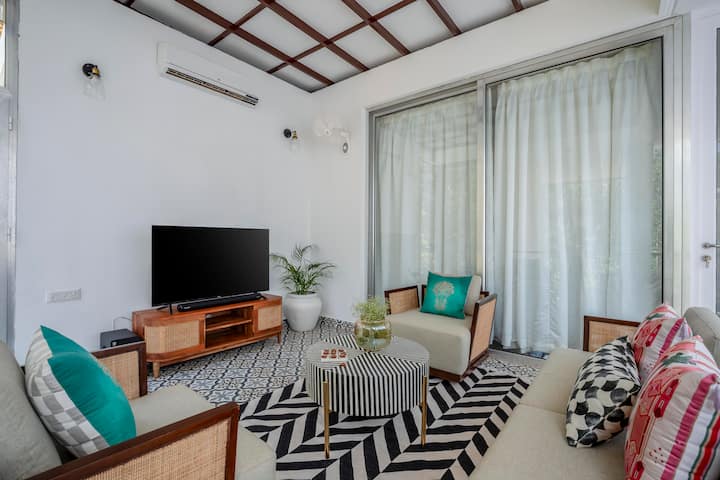A chic center table and thoughtfully placed décor add to the charm, while the open layout and high ceiling enhance the sense of space.
