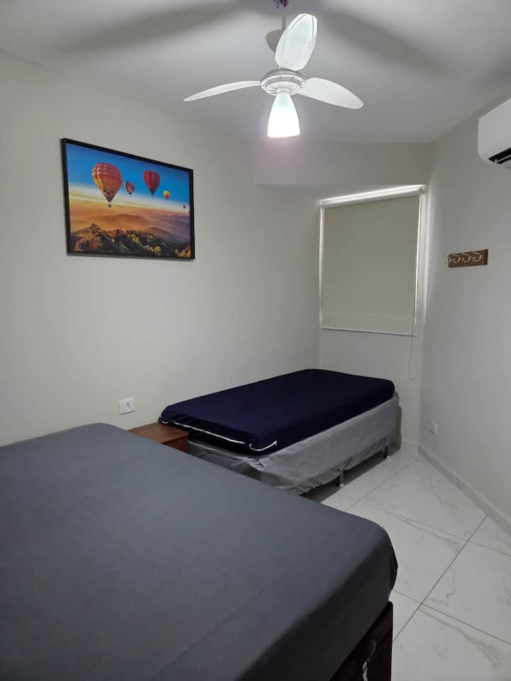 Bedroom with a double bed and a trundle bed, air-conditioning, and a ceiling fan.