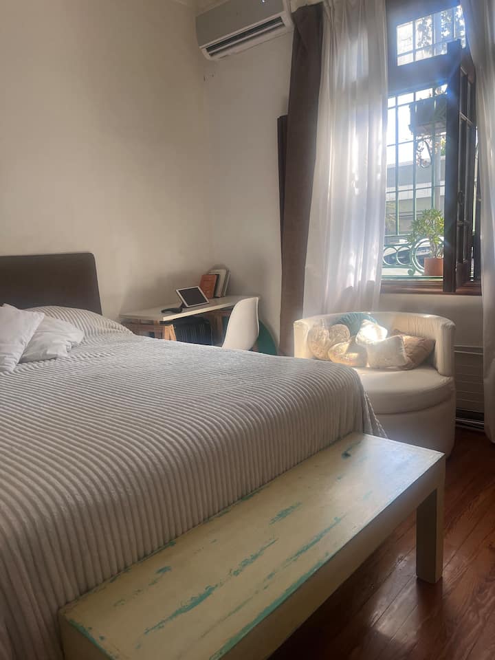 Ambiente con cama queen y escritorio en Villa del Parque