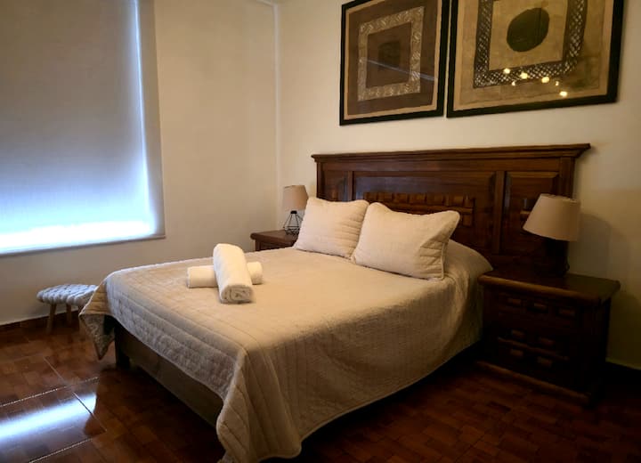 Recámara cómoda con cama amplia, iluminación cálida y detalles elegantes que invitan al descanso total.