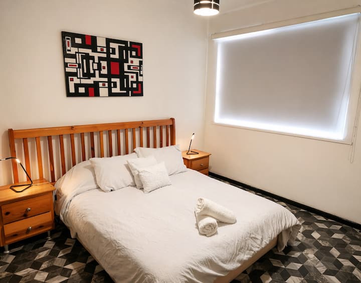 Recámara cómoda y funcional con cama amplia, iluminación cálida y decoración moderna para un descanso placentero.
