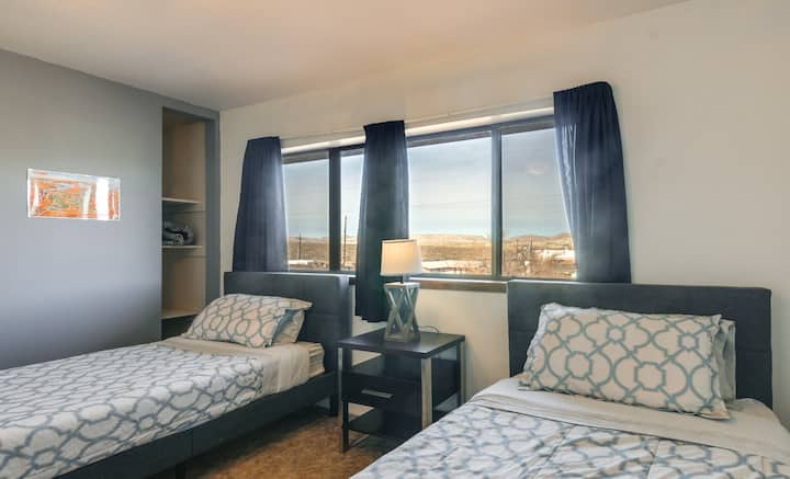 your second bedroom has two single beds a closet and a leather chair. additional bedding is inside the closet or on the shelf