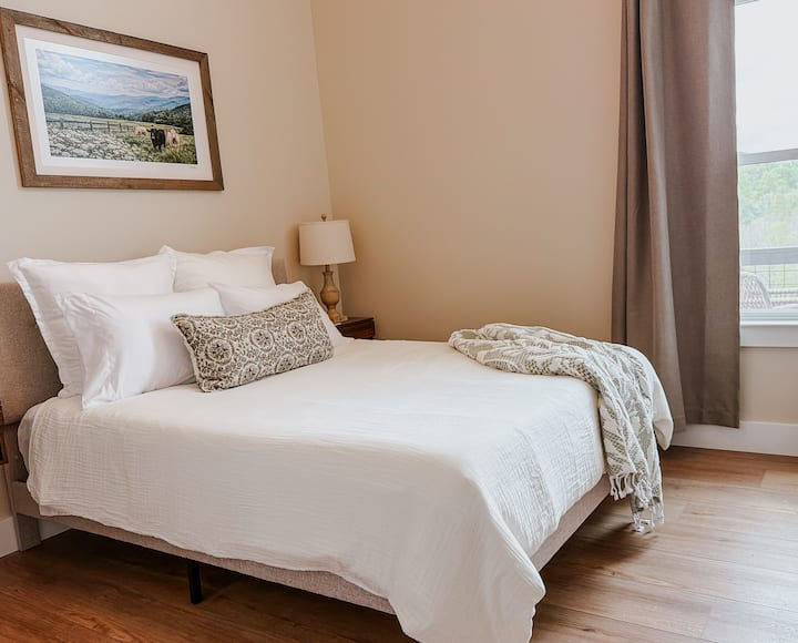 Comfortable queen bedroom with soft linens and neutral tones for a restful stay.