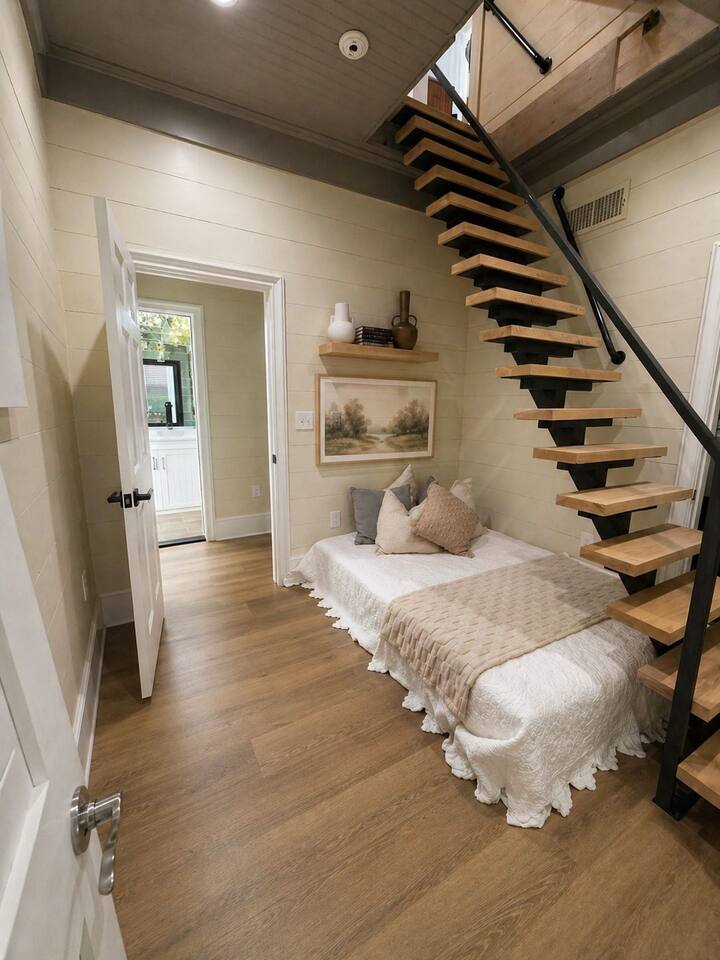 Chambre moderne et confortable avec plancher en bois clair et escalier en colimaçon.