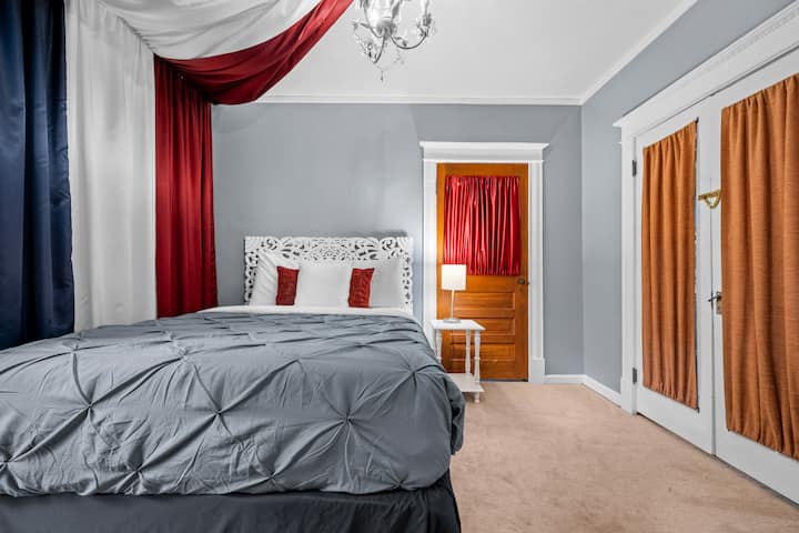 Cómoda habitación principal en la planta baja con cama tamaño king, ropa de cama lujosa y colchón de alta gama, con vistas al arroyo y un apacible ambiente victoriano majestuoso