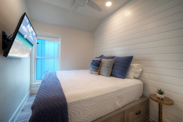 El dormitorio 2 cuenta con una cama tamaño king, TV y acceso a un baño compartido en el pasillo.