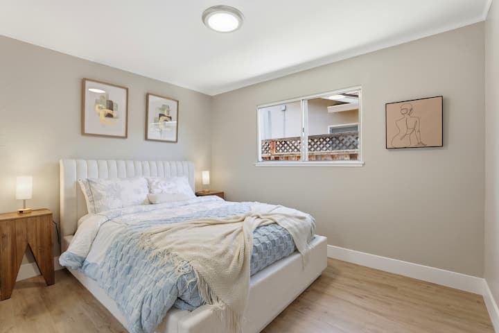 Calm, light-filled bedroom with plush queen bed and sleek wood floors