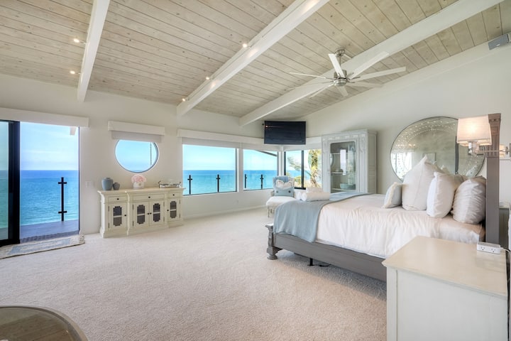Impresionante suite principal con vistas panorámicas al mar, techos altos y balcón privado.