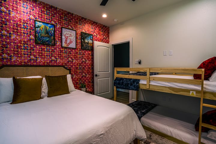 Perfecta para familias o viajes en grupo, esta colorida habitación en el piso de arriba cuenta con una cama tamaño queen, literas individuales y un atrevido papel tapiz de diseño. El diseño divertido le da a cada persona su propio espacio, a la vez que mantiene la habitación acogedora, funcional y llena de personalidad.