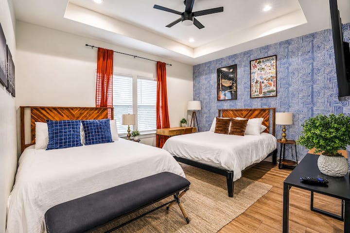 Ideal para grupos que viajan juntos, este dormitorio en el piso de arriba ofrece dos camas tamaño queen, una pared decorativa llamativa y mucha luz natural. Un escritorio dedicado agrega comodidad adicional, mientras que el baño privado conectado facilita la preparación de los huéspedes