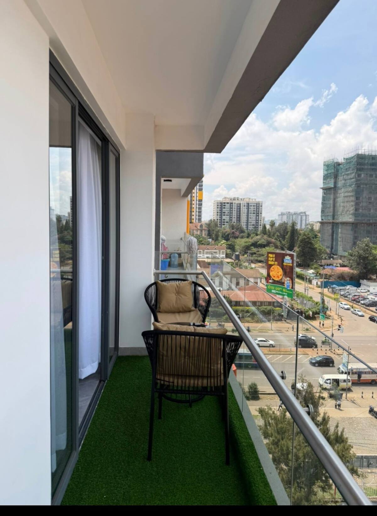 Private balcony with wicker chair overlooking central Nairobi street