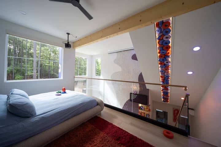 Bright primary suite with forest views and striking modern design