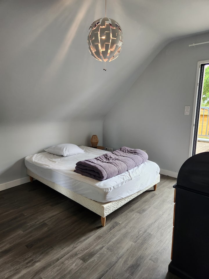 Spálňa na poschodí s manželskou posteľou a písacím stolom. Priamy prístup na balkón